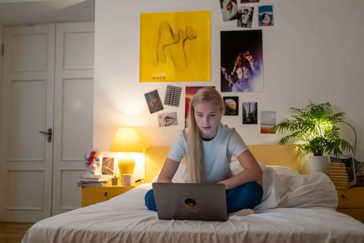 a girl on her bed with a laptop